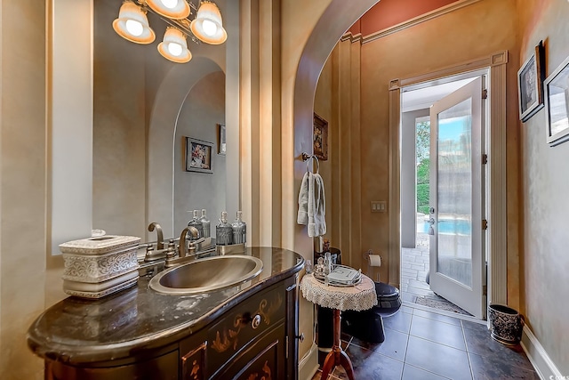 bathroom with toilet, vanity, and tile patterned floors