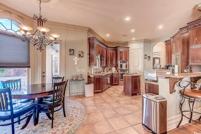 kitchen featuring sink, crown molding, hanging light fixtures, kitchen peninsula, and a chandelier