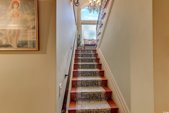 stairway with a chandelier