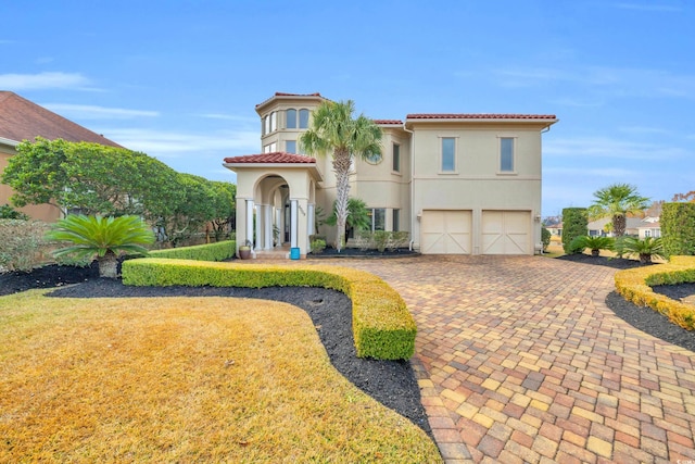 mediterranean / spanish-style home featuring a garage and a front lawn