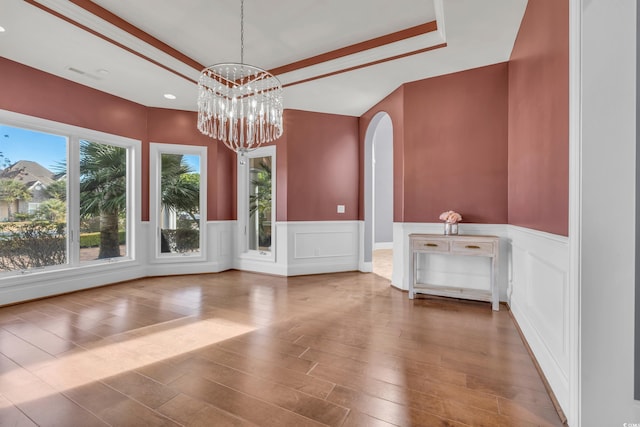 unfurnished dining area with hardwood / wood-style floors and a notable chandelier