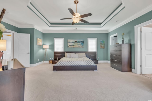 carpeted bedroom with a tray ceiling, ceiling fan, and crown molding