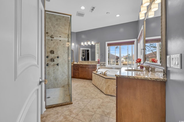 bathroom featuring plus walk in shower, vanity, and tile patterned floors