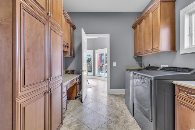 laundry area with cabinets, separate washer and dryer, plenty of natural light, and light tile patterned flooring