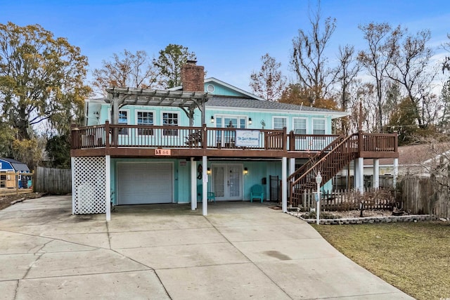 view of front of house with a pergola, a wooden deck, french doors, and a garage