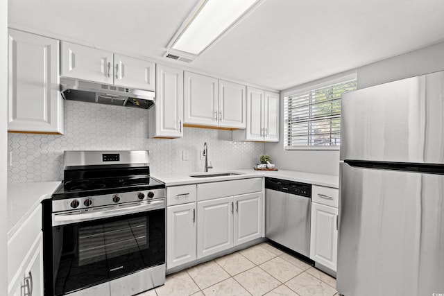 kitchen with sink, white cabinetry, light tile patterned floors, stainless steel appliances, and decorative backsplash