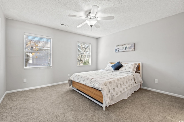 bedroom featuring ceiling fan, carpet, and a textured ceiling