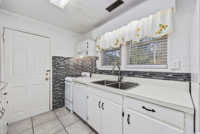 kitchen featuring white cabinetry, sink, crown molding, white appliances, and light tile patterned floors