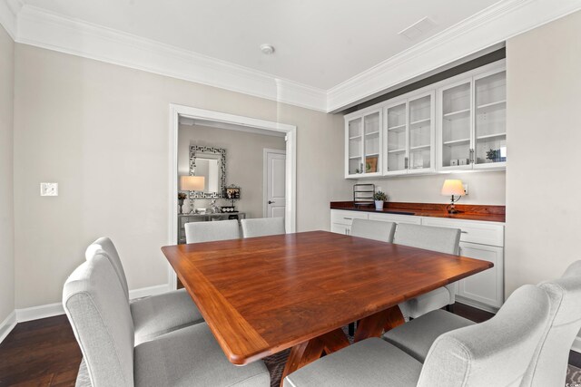 dining space with dark hardwood / wood-style flooring and ornamental molding