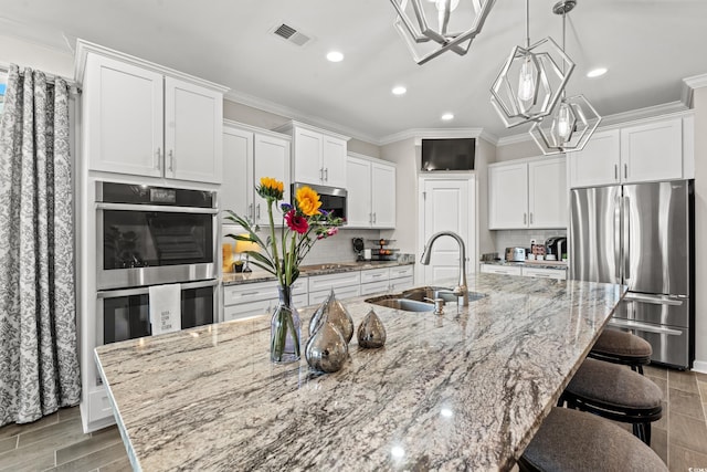 kitchen with white cabinetry, a large island, sink, and stainless steel appliances