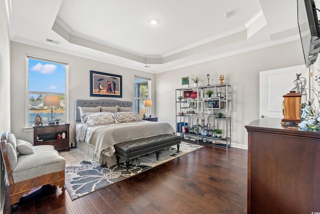 bedroom featuring a raised ceiling, wood-type flooring, and ornamental molding