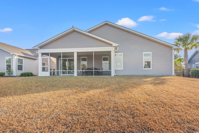 back of house with a lawn and a sunroom