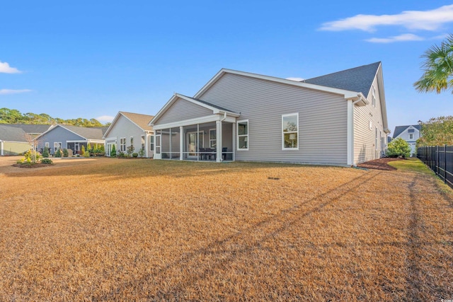 back of house featuring a sunroom and a yard