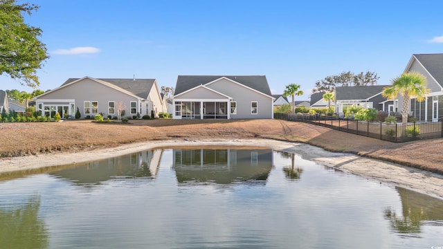 back of house featuring a sunroom and a water view