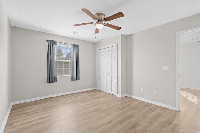 unfurnished bedroom with a closet, ceiling fan, light hardwood / wood-style flooring, and a textured ceiling