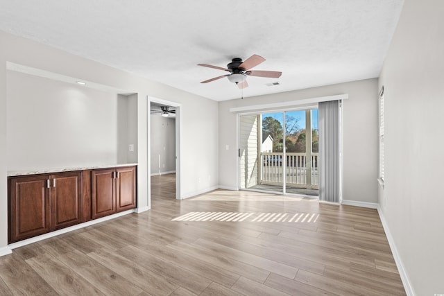 spare room with a textured ceiling and light hardwood / wood-style flooring