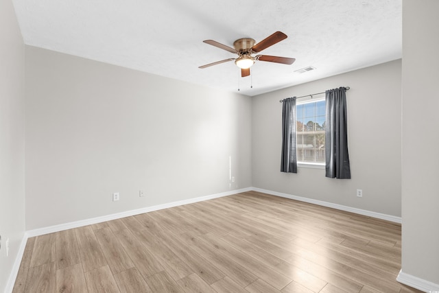 spare room featuring ceiling fan, light wood-type flooring, and a textured ceiling