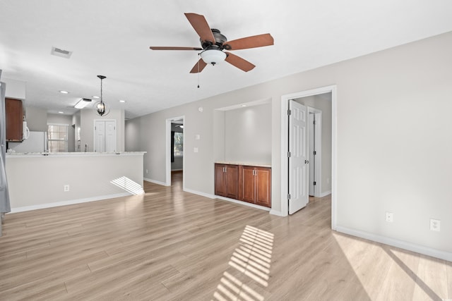 unfurnished living room with ceiling fan, light hardwood / wood-style floors, and a healthy amount of sunlight