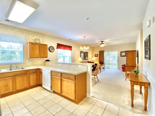 kitchen with kitchen peninsula, sink, white dishwasher, and light colored carpet