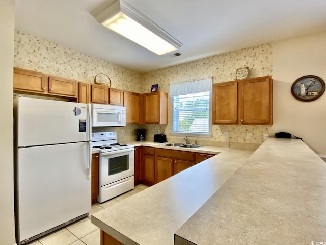 kitchen with kitchen peninsula, sink, light tile patterned floors, and white appliances