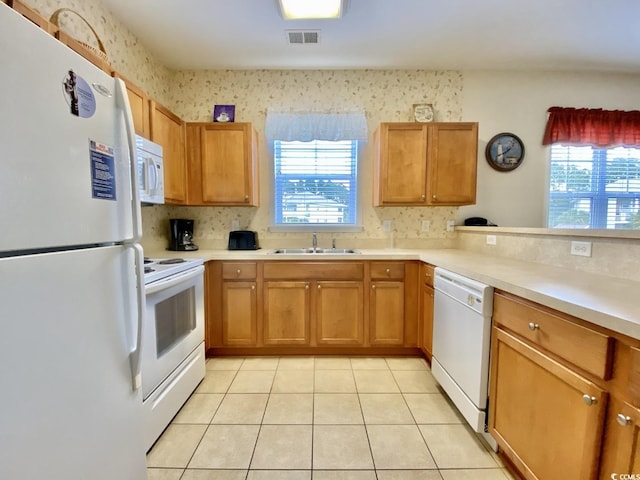 kitchen featuring light tile patterned flooring, white appliances, and sink