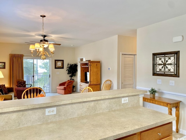 kitchen featuring ceiling fan with notable chandelier