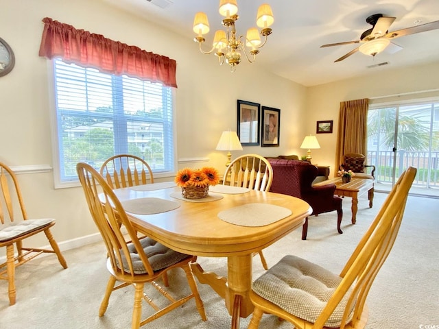 carpeted dining room featuring ceiling fan with notable chandelier