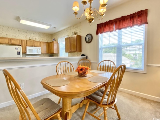 carpeted dining room featuring an inviting chandelier