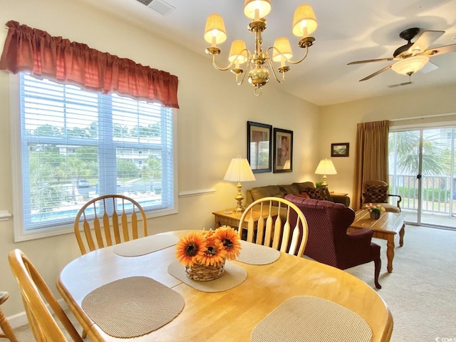 dining space featuring a wealth of natural light, carpet floors, and ceiling fan with notable chandelier