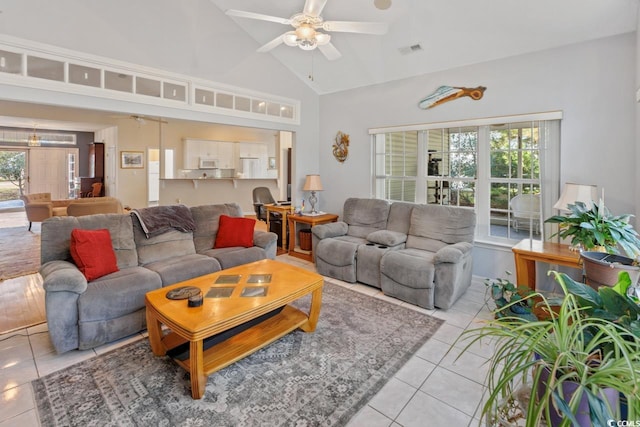 tiled living room featuring ceiling fan and high vaulted ceiling