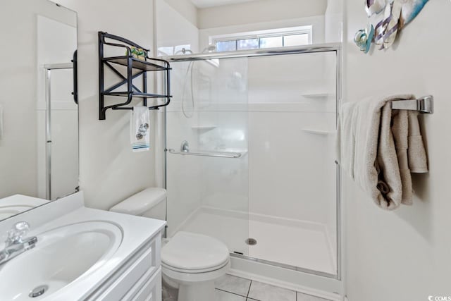 bathroom featuring tile patterned floors, vanity, toilet, and a shower with shower door