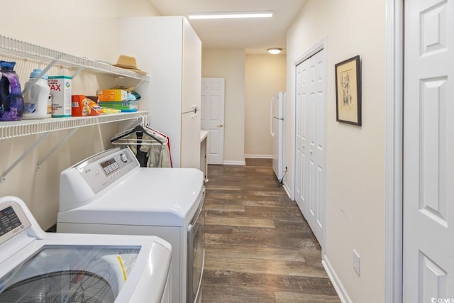 clothes washing area with independent washer and dryer and dark hardwood / wood-style flooring