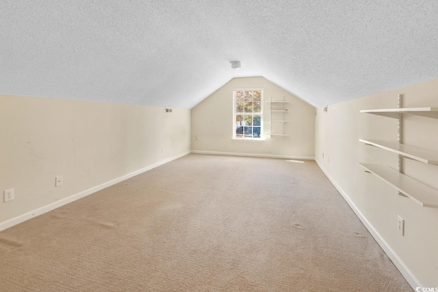 bonus room featuring a textured ceiling, light carpet, and lofted ceiling