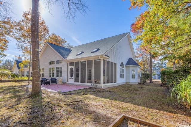 rear view of property with a sunroom, a patio area, and a yard