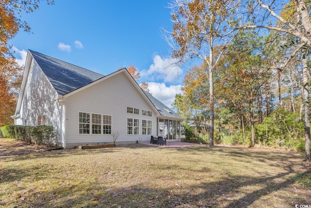 back of house with a lawn and a patio