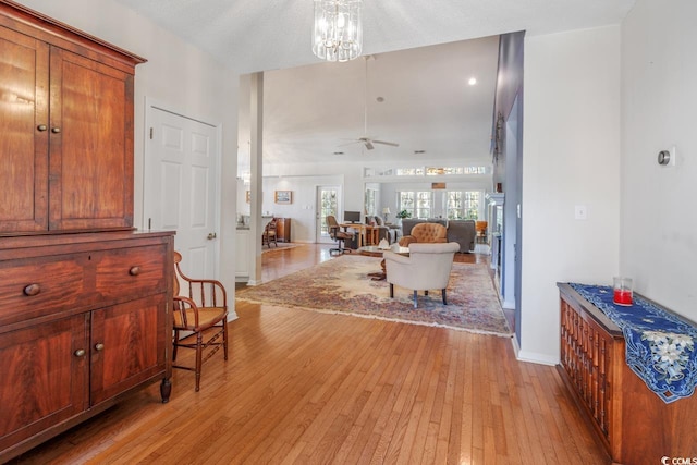 foyer entrance featuring ceiling fan with notable chandelier, a textured ceiling, and light hardwood / wood-style flooring