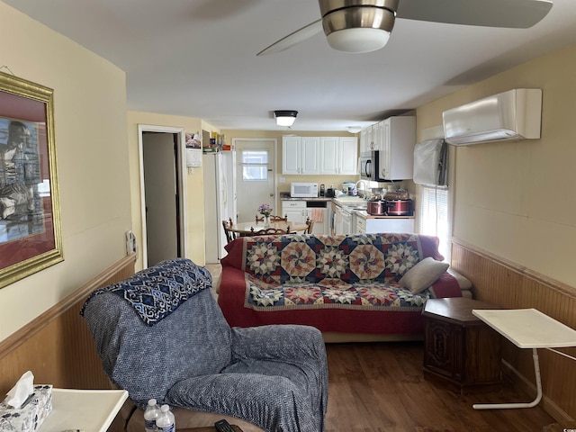 living room featuring wood walls, plenty of natural light, and dark wood-type flooring