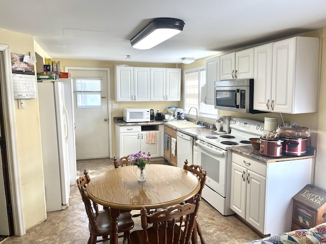 kitchen with white cabinets, a healthy amount of sunlight, white appliances, and sink