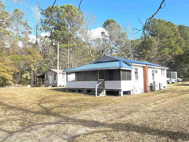 view of front of property featuring a sunroom and a front lawn