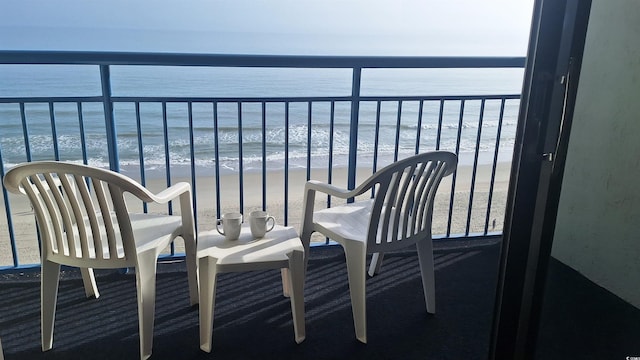 balcony with a water view and a beach view