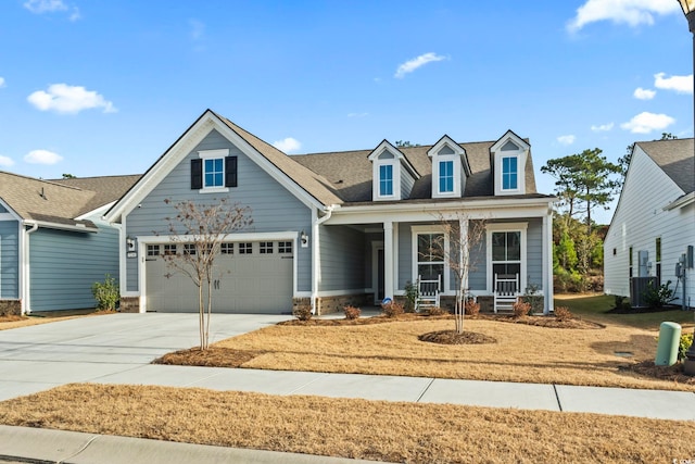 view of front of home with a porch, a garage, and central AC