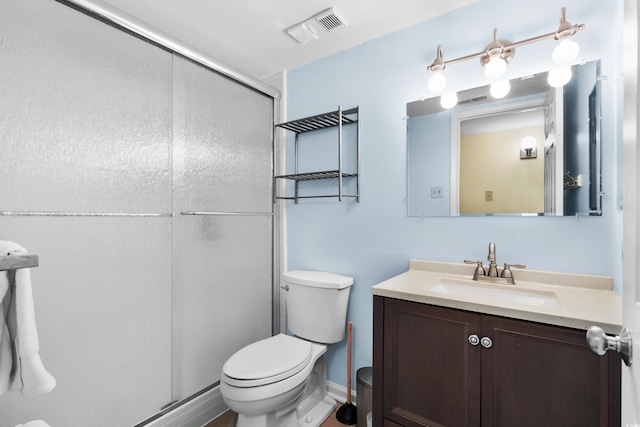 bathroom with vanity, a shower with shower door, and toilet