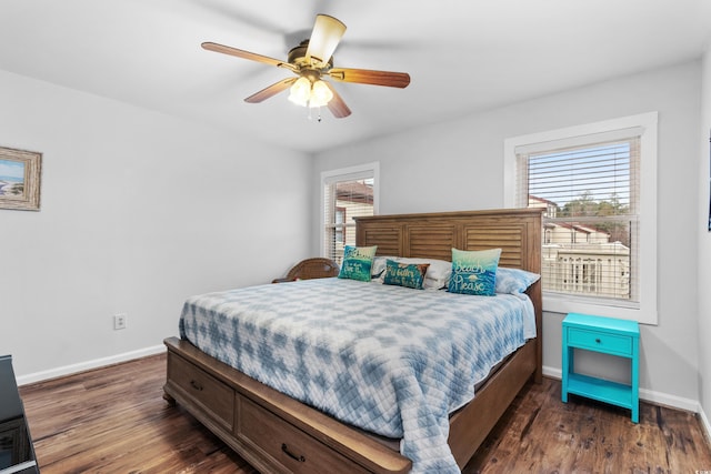 bedroom featuring dark hardwood / wood-style floors, multiple windows, and ceiling fan