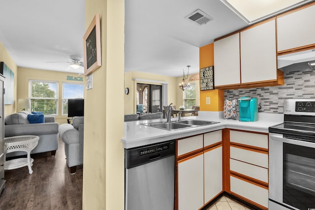 kitchen with sink, stainless steel appliances, tasteful backsplash, light hardwood / wood-style flooring, and white cabinets