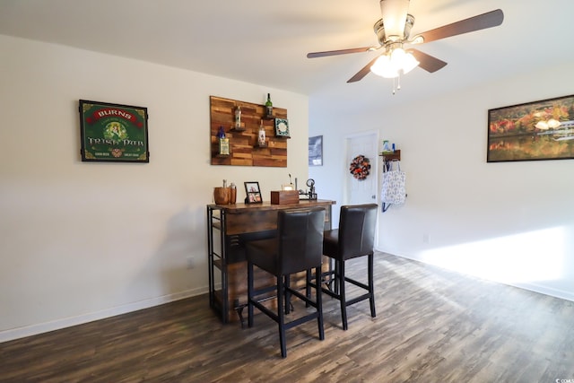 bar with ceiling fan and dark wood-type flooring