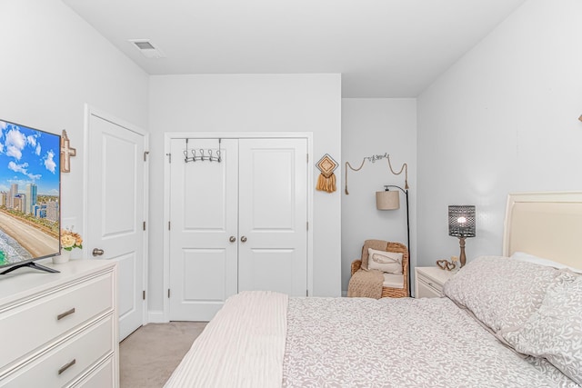 bedroom featuring visible vents, a closet, and light colored carpet