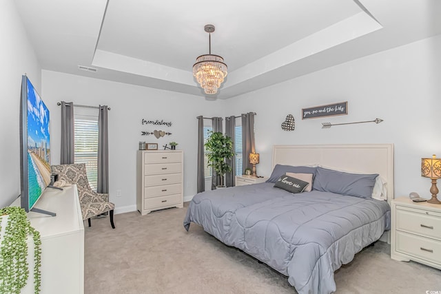 bedroom with light carpet, baseboards, visible vents, a raised ceiling, and an inviting chandelier