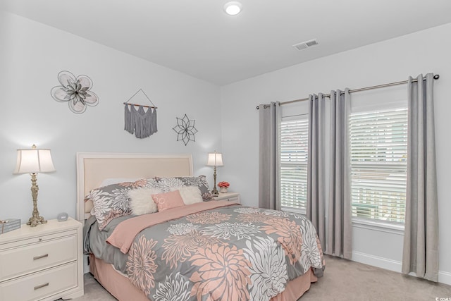 bedroom with baseboards, visible vents, and light colored carpet