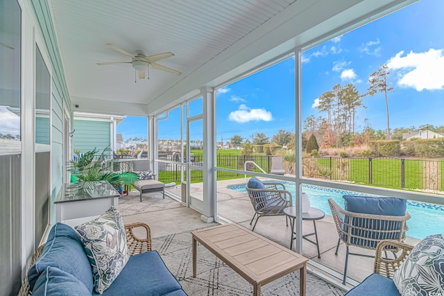 sunroom / solarium featuring a ceiling fan