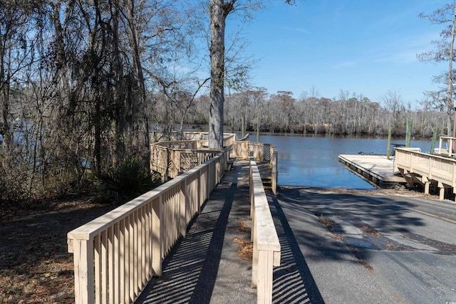 dock area with a water view and a view of trees